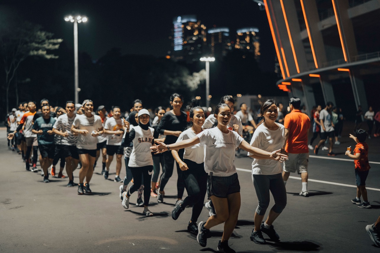 Runners moving together on a city road during a night event.