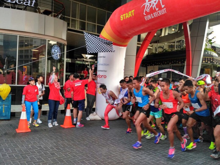 Runners gathered beneath the red Run and Recruit start arch.