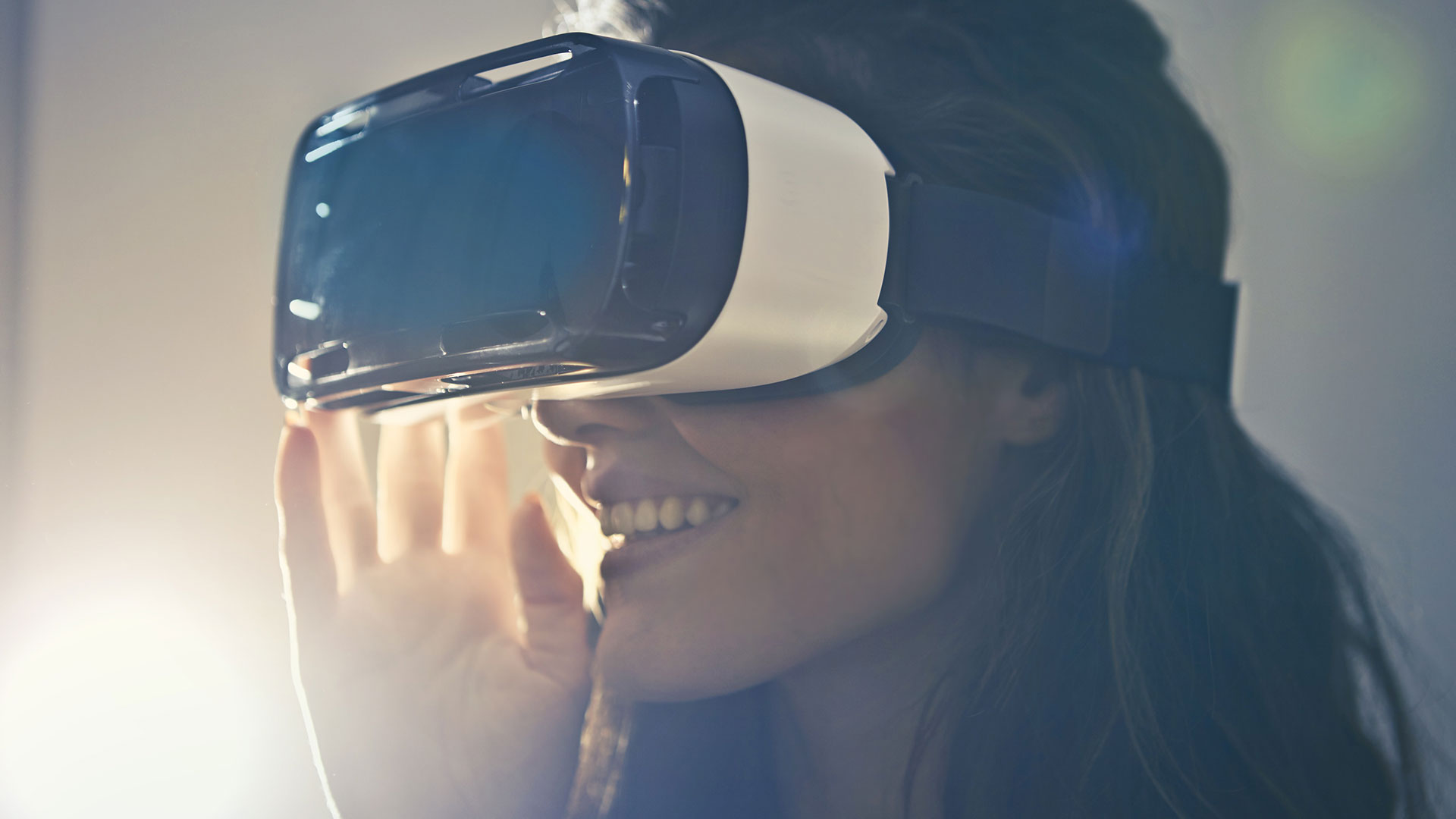 A person smiles while wearing a virtual reality headset.
